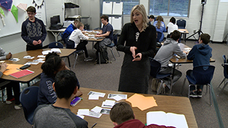 Teacher giving students at table instructions