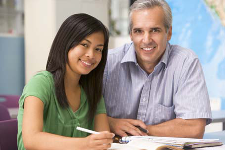 teacher and mentor reviewing documents and smiling for the camera