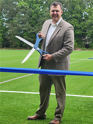 Pinckneyville MS Principal Todd Marschke cutting the ribbon for their new soccer field
