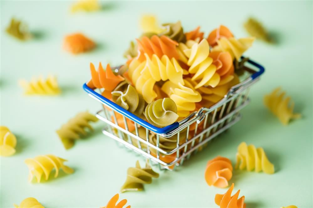 Dried pasta overflowing a tiny basket