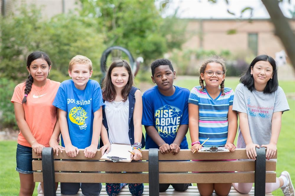 Students standing behind a bench Students standing behind a bench