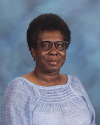 a woman in a blue shirt and black frame glasses
