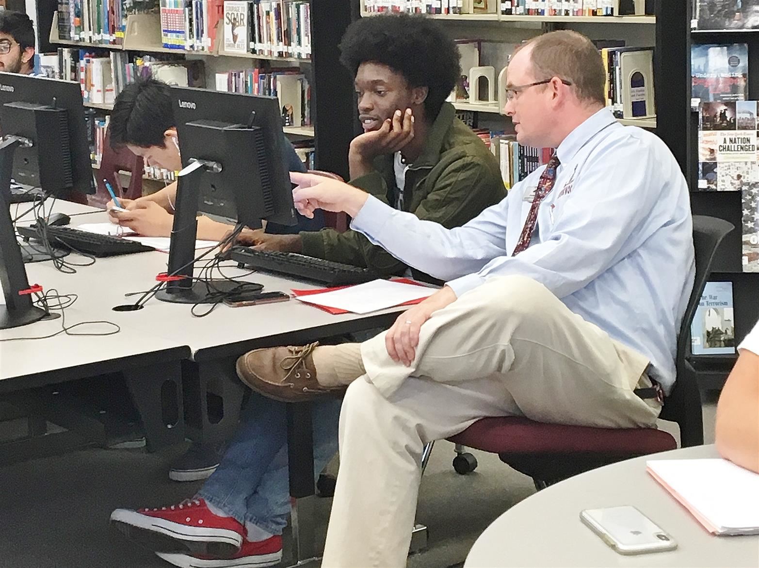 Teacher instructing student at the computer